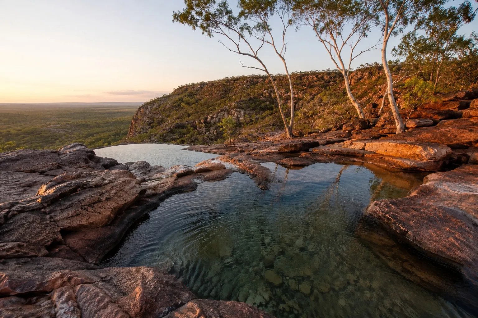 Natural stone infinity pools at the top of Gunlom Falls in Kakadu National Park NT at golden hour