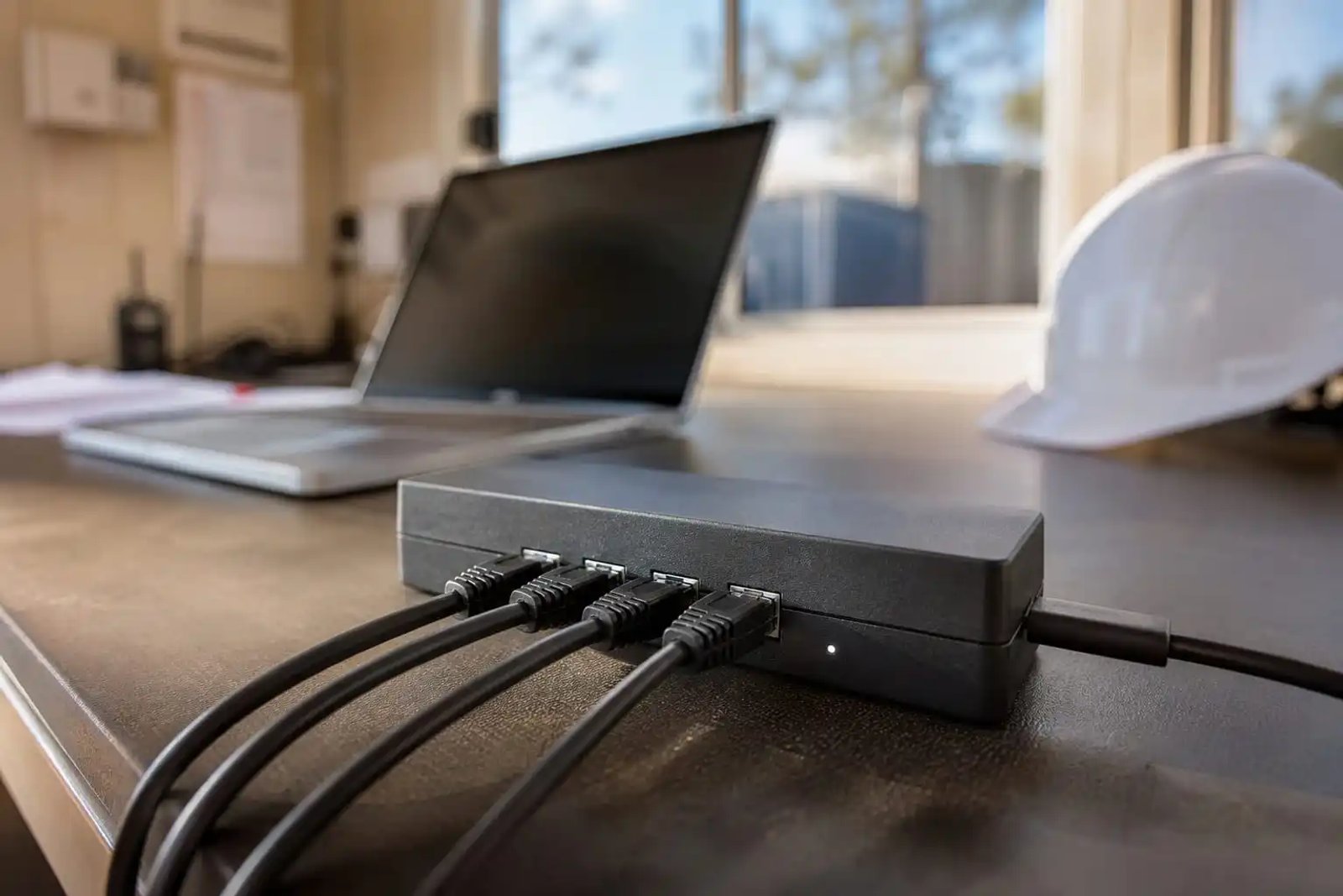 Starlink Mini 4-Port Ethernet Adapter in a remote Australian site office with Cat6 cables connected.