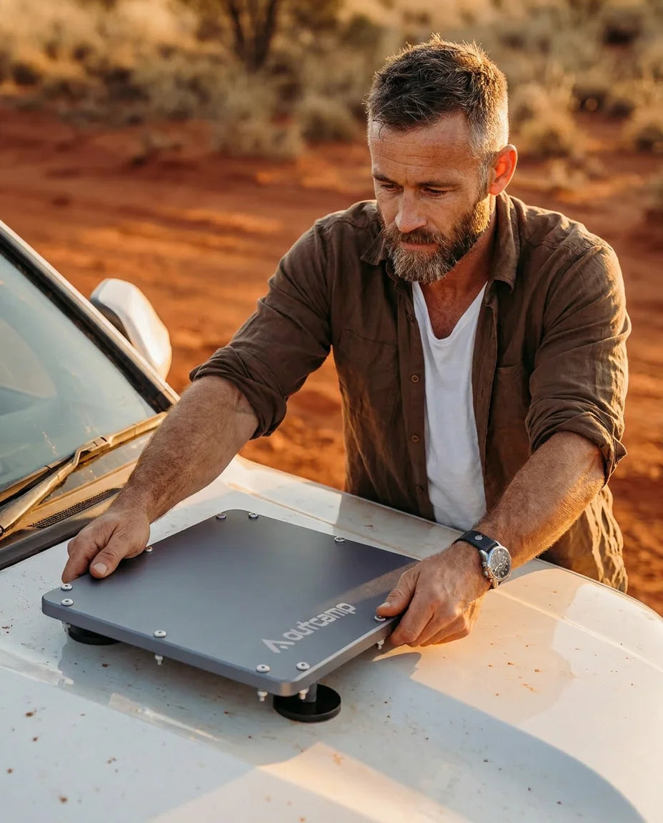 Outcamp brand ambassador placing MagLock Pro Starlink Mini magnetic mount onto vehicle in Australian outback
