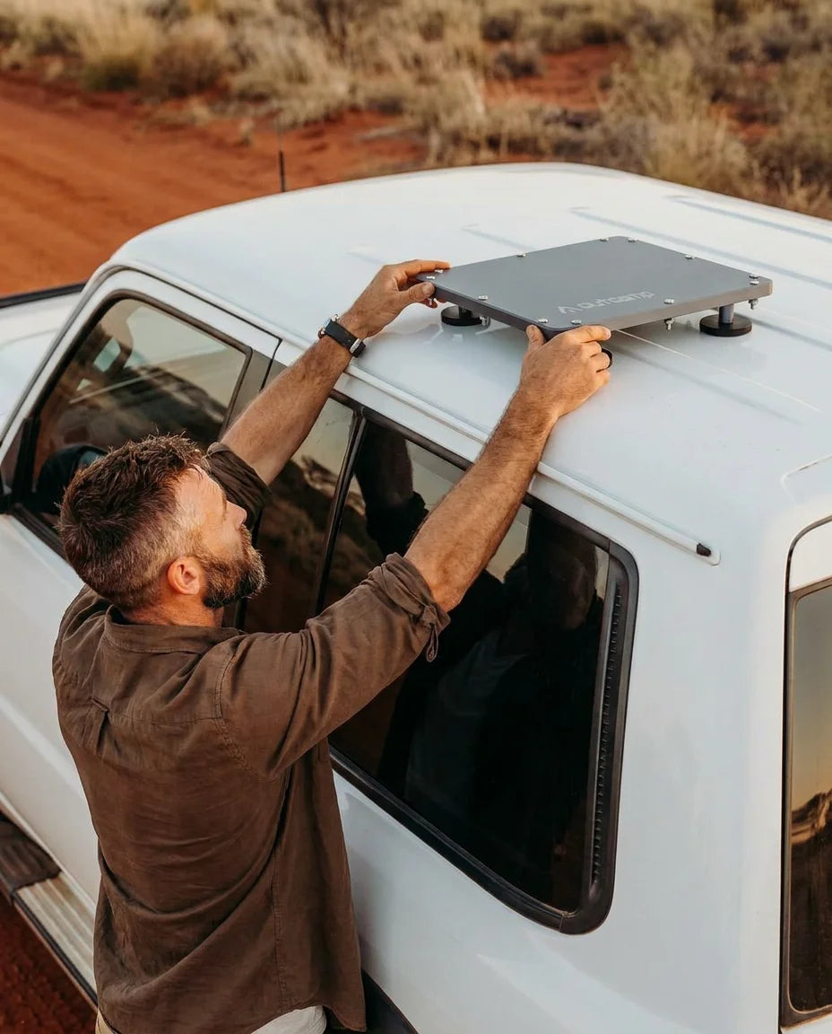 Outcamp brand ambassador placing MagLock Pro Starlink Mini magnetic mount on roof of Nissan Patrol Y62 wagon in Australian outback