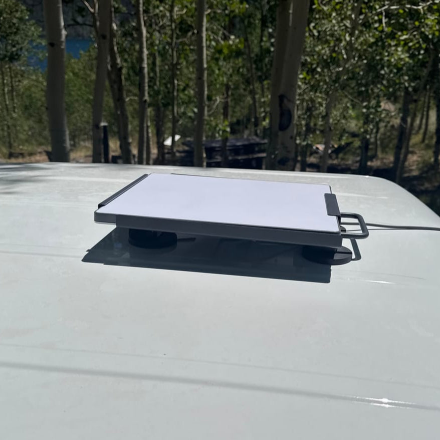 A magnetic roof mount designed to hold a Starlink Mini device, featuring a dark grey steel structure with four black magnets, mounted on the top of a vehicle.